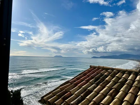 Vista dal loft su un tetto di tegole fino al mare