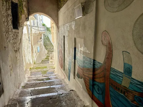 Un vicolo del centro storico con un muro dipinto